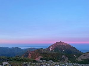 日の出の光を浴びるニペソツ山